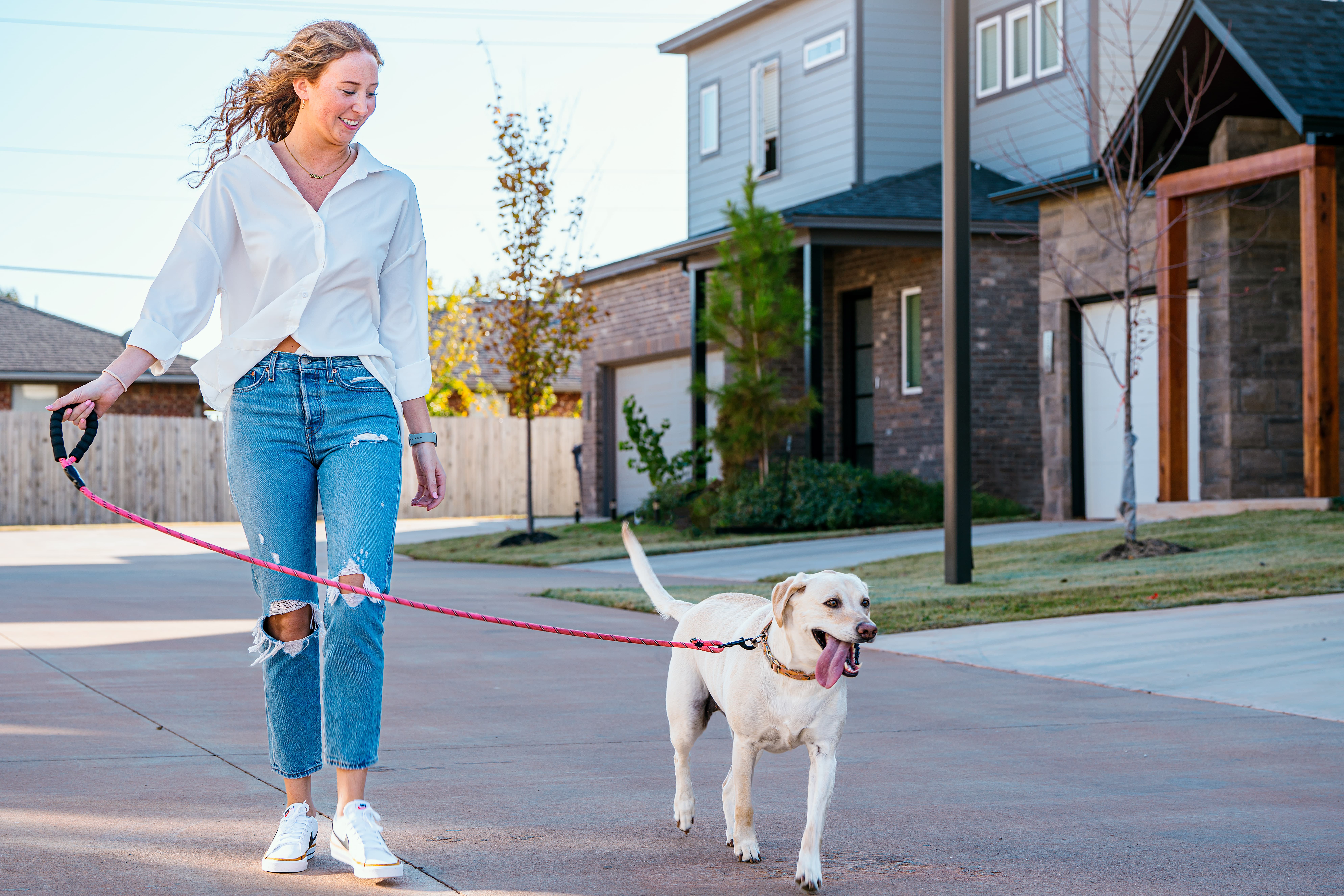 Woman walking her dog down the street of a TimberCraft community
