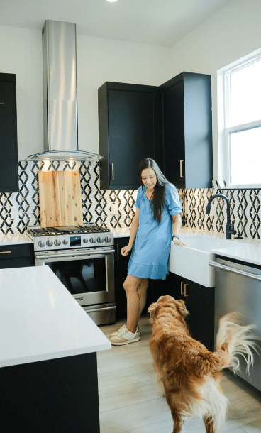 Woman greeting her dog in her kitchen