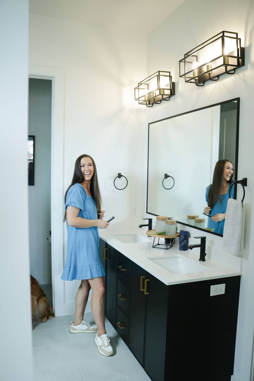 Woman laughing in front of the bathroom sink, looking at the camera