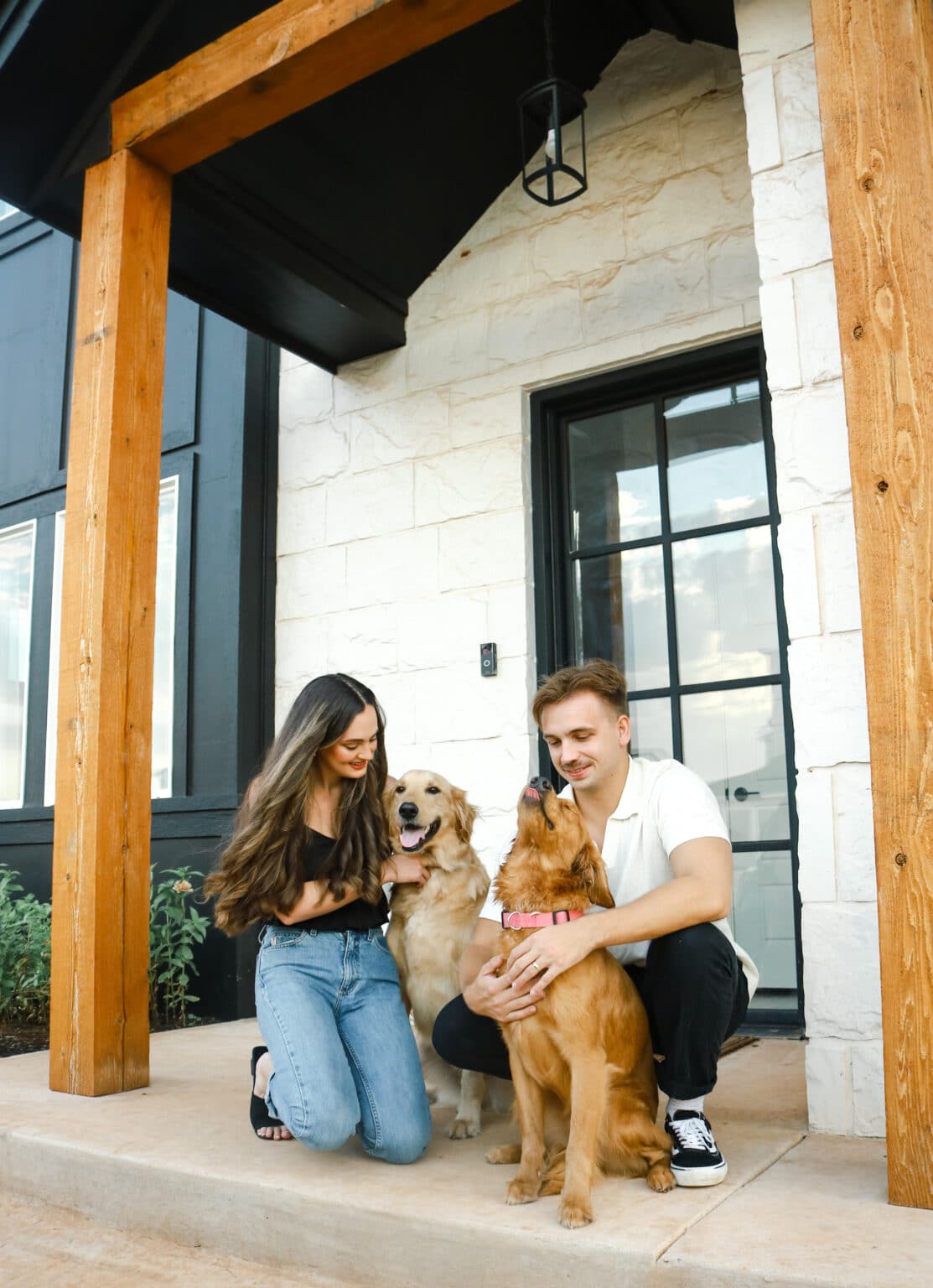 Couple petting their dogs in front of their TimberCraft home front door